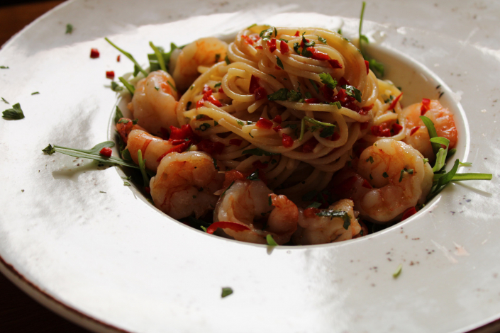 Teller mit Spaghetti mit Scampi und Kräutern angerichtet im Restaurant Ristorante Il Cortile in Korschenbroich
